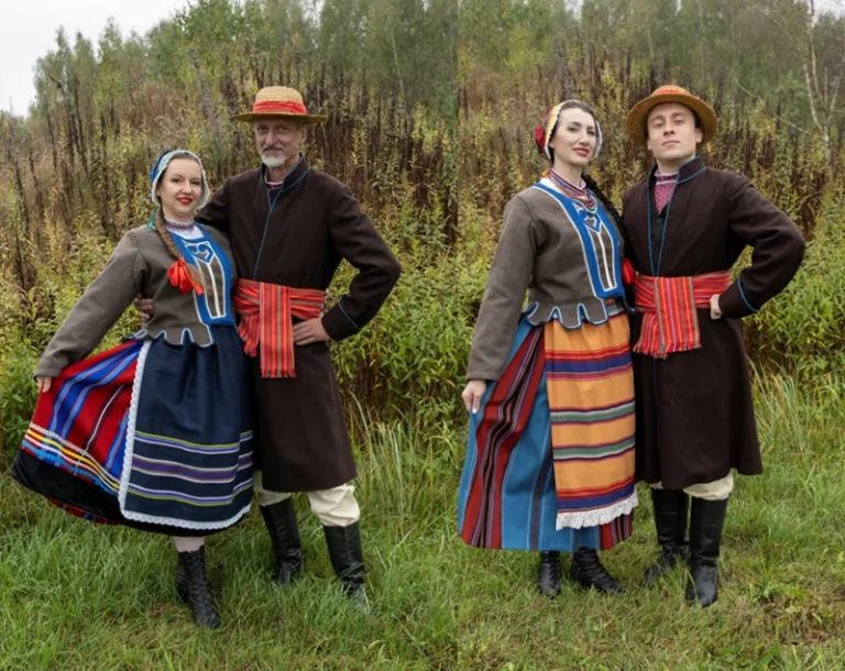 Cztery osoby w tradycyjnych strojach podlaskich – dwie kobiety i dwóch mężczyzn – pozują parami na tle jesiennego krajobrazu z trawami i drzewami, w radosnej, rustykalnej atmosferze.